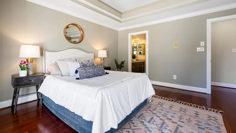 Neatly made bed with white linens and two nightstand lamps, the kind of room to come home to after surgery