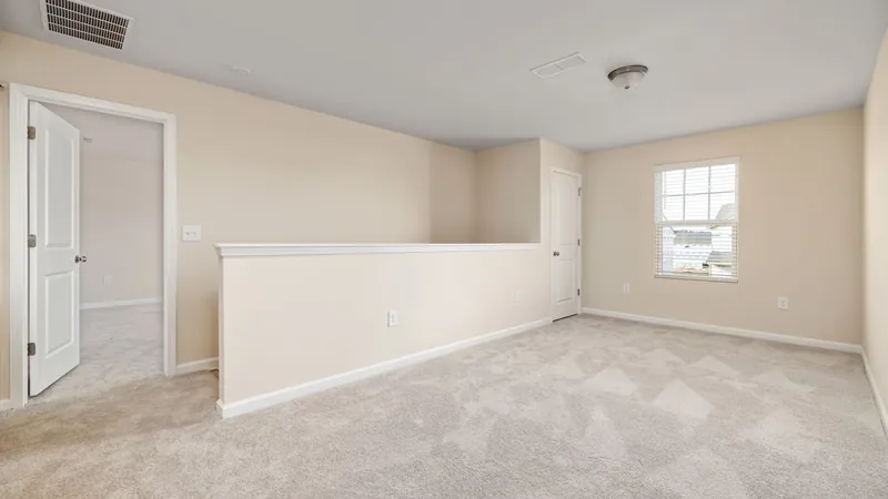 Empty room with beige walls and wall-to-wall carpet