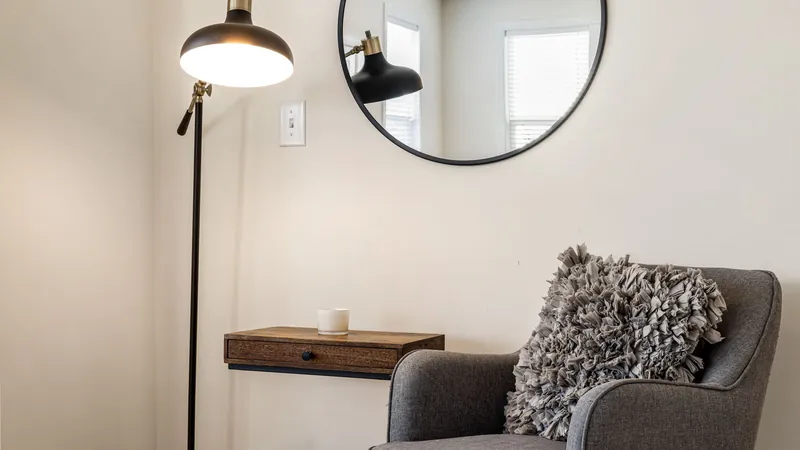 Quiet living room corner with an armchair, shelf and floor lamp