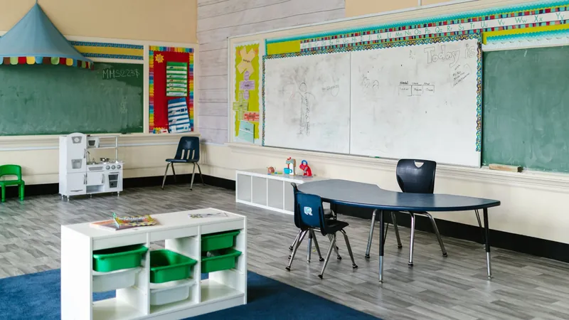 Empty preschool classroom with small tables, chairs and chalkboards