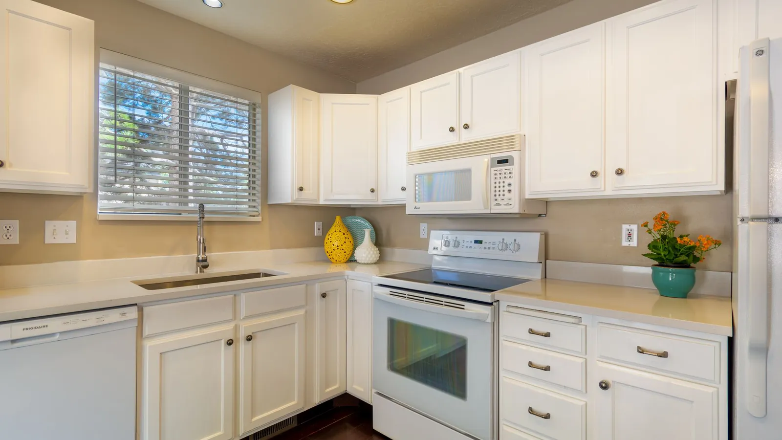 Bright white kitchen with clean counters and appliances