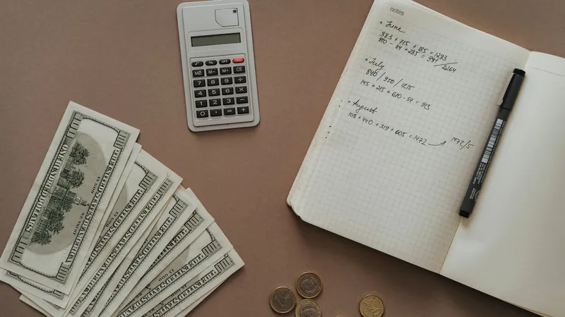 Calculator, notebook and dollar bills on a desk