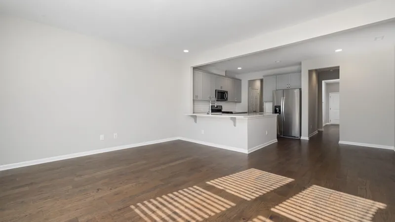 Empty apartment with an open kitchen and hardwood floors