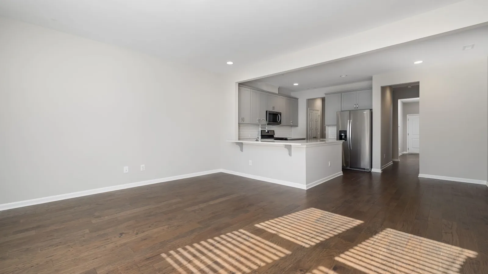 Empty apartment with an open kitchen and hardwood floors