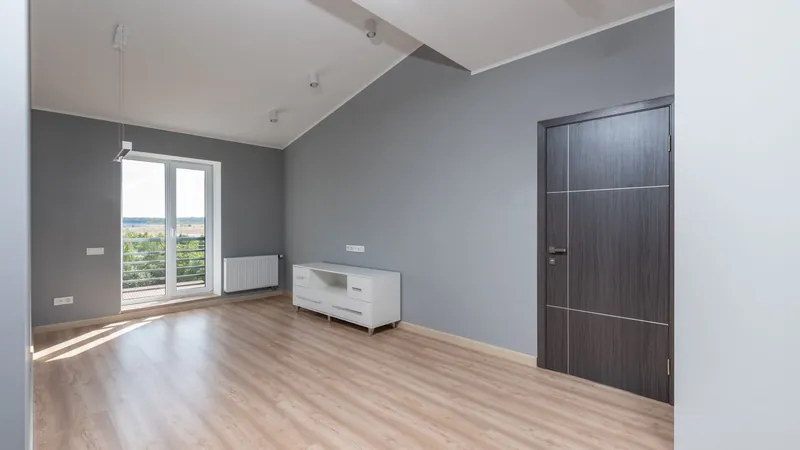 Bright empty room with hardwood floors and a large window