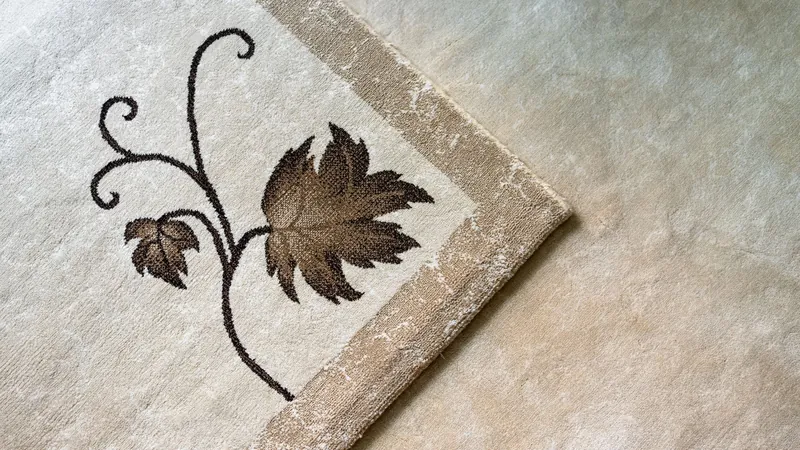 Close-up of a beige carpet with a leaf pattern