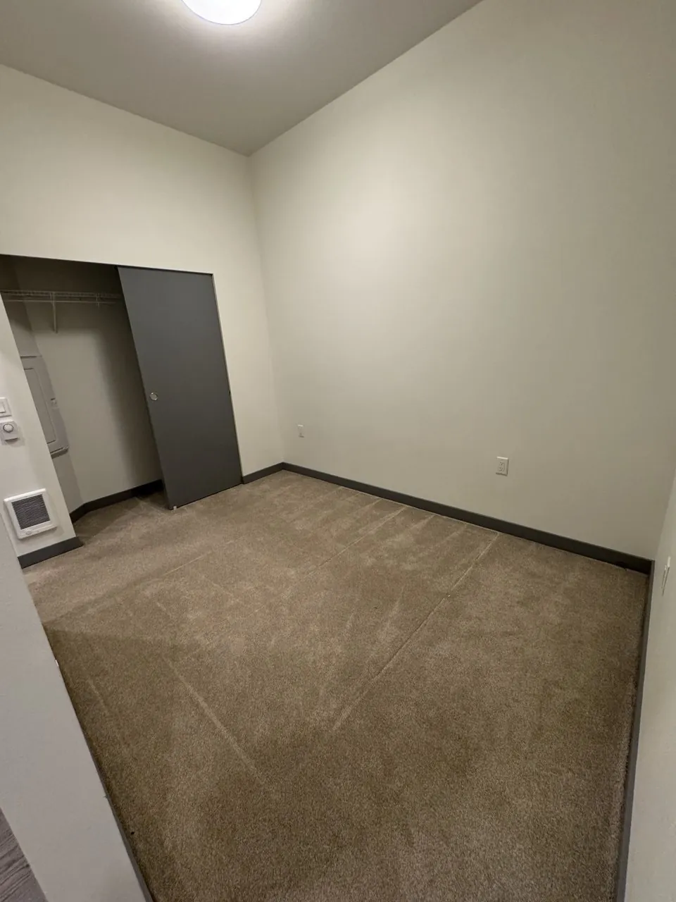 Before: empty bedroom carpet by a gray sliding closet