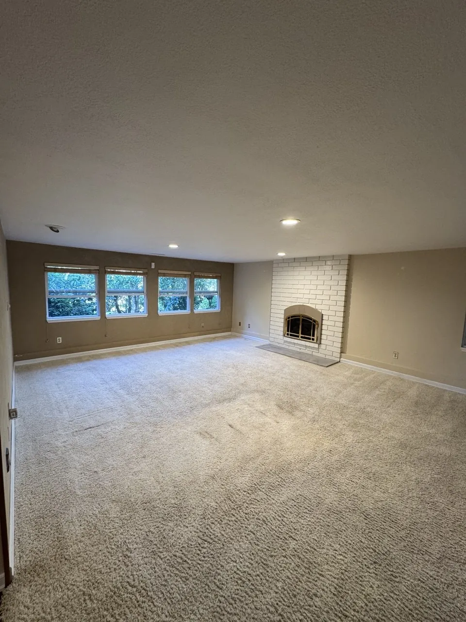 Before: large living room carpet with a brick fireplace