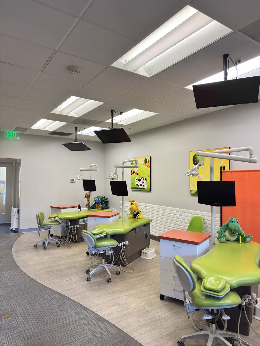 Open bay area of a children's dental clinic, chairs and carts in place