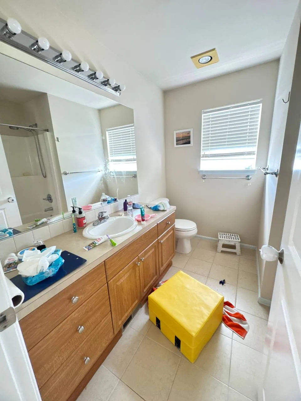 Before: bathroom vanity with long mirror, light bar and tile floor