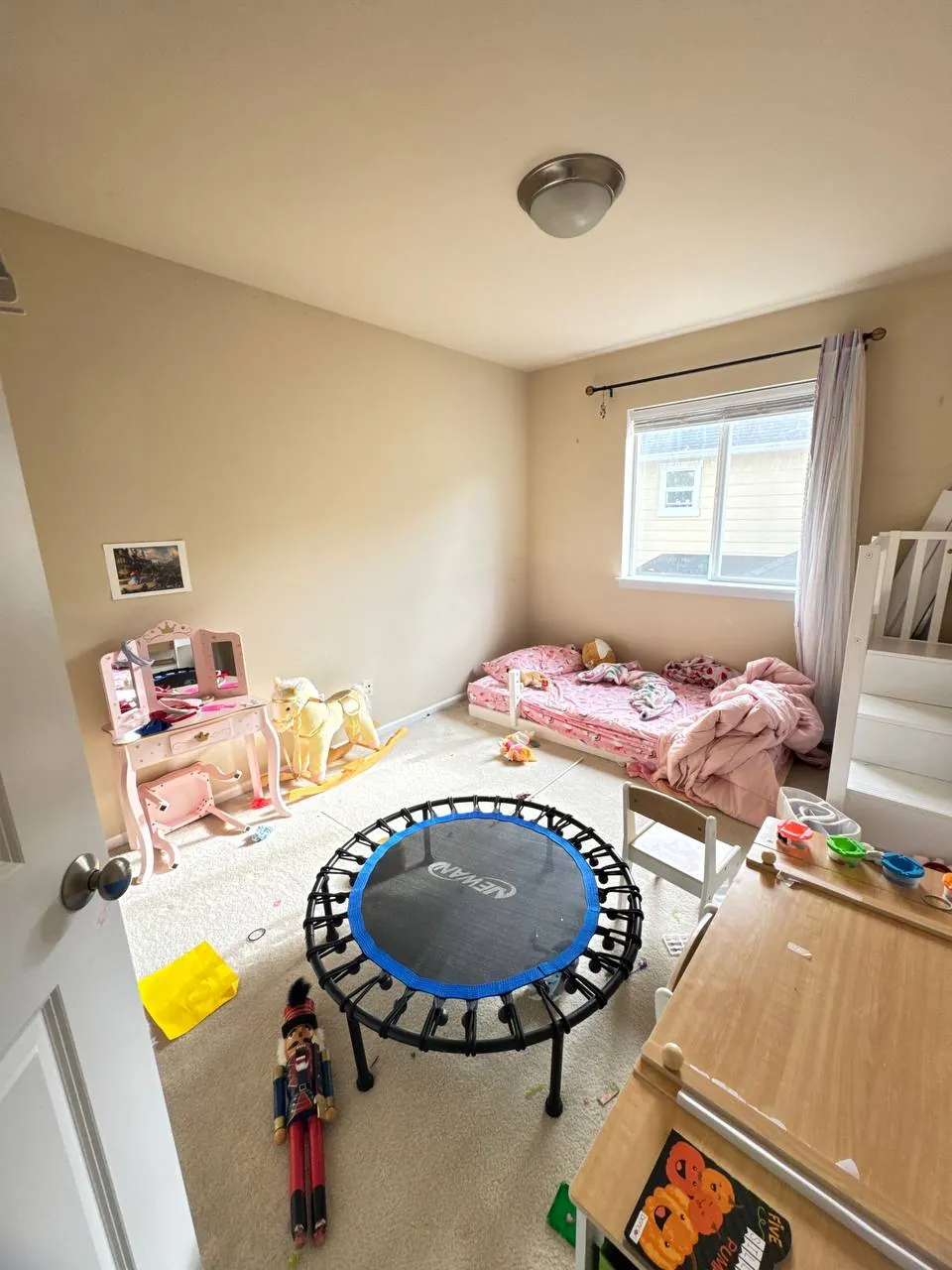 Before: child's bedroom with toddler bed and play table on carpet