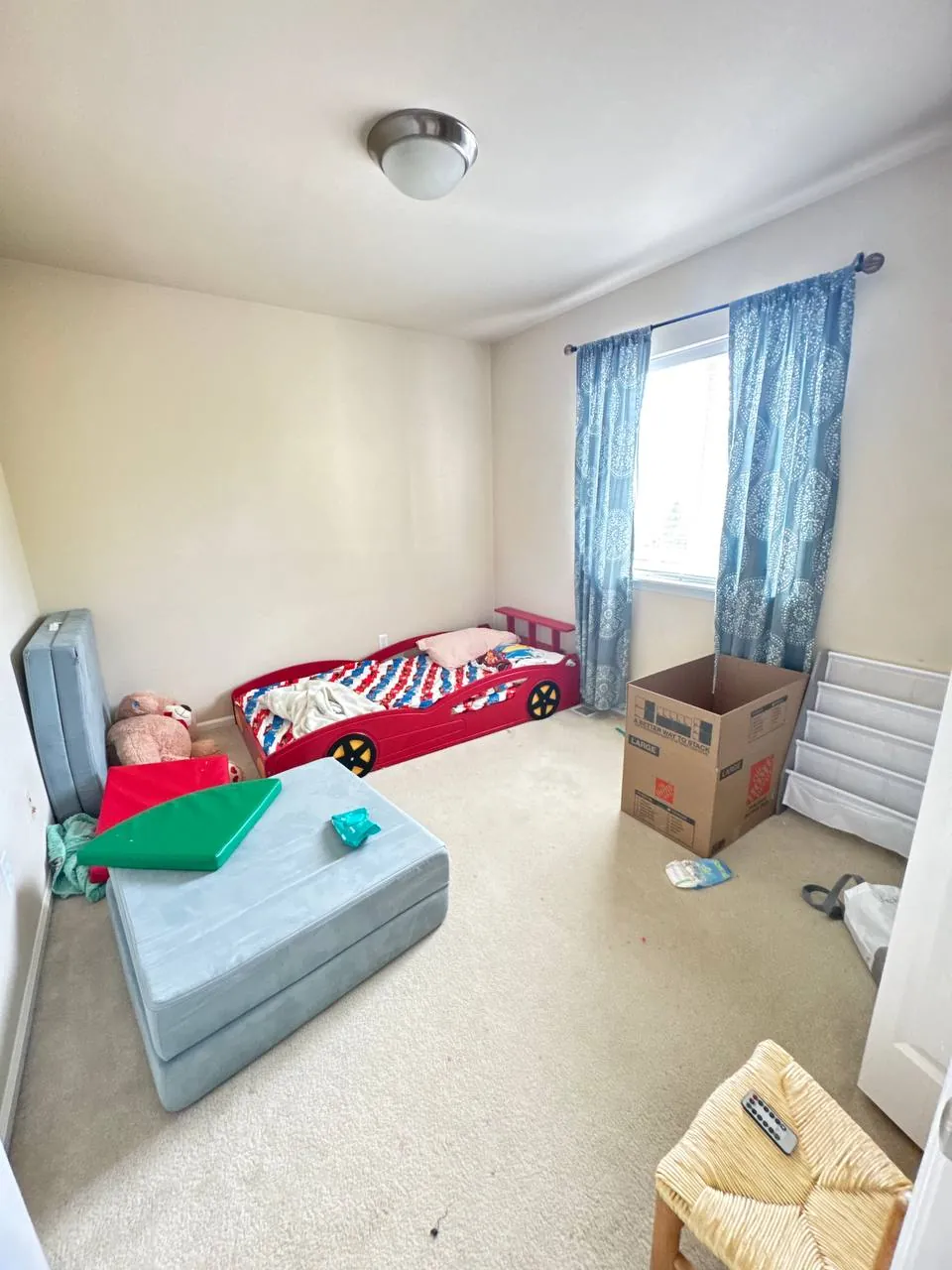 Before: bedroom with race-car bed and blue curtains