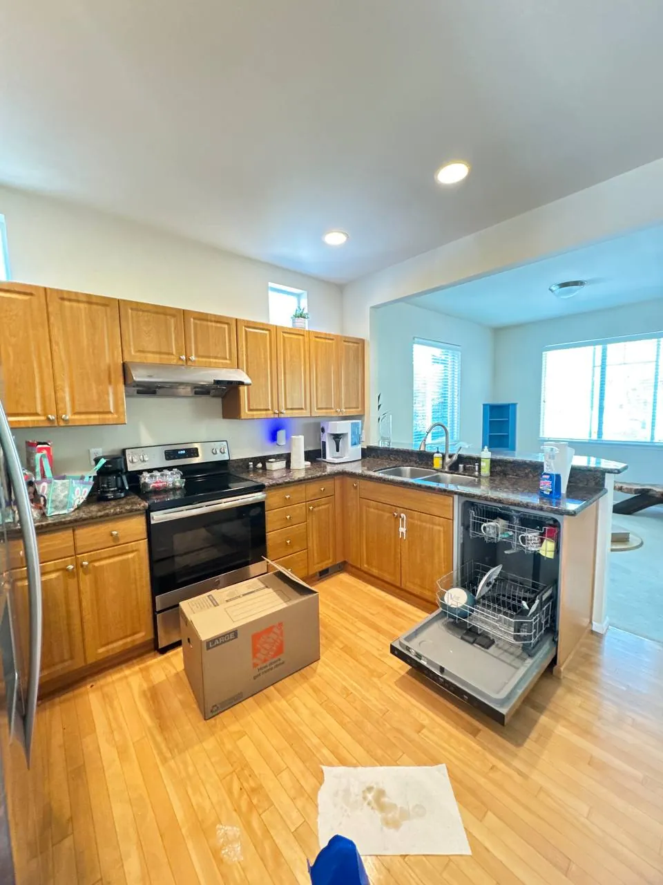 Before: kitchen with oak cabinets, granite counters and hardwood floor