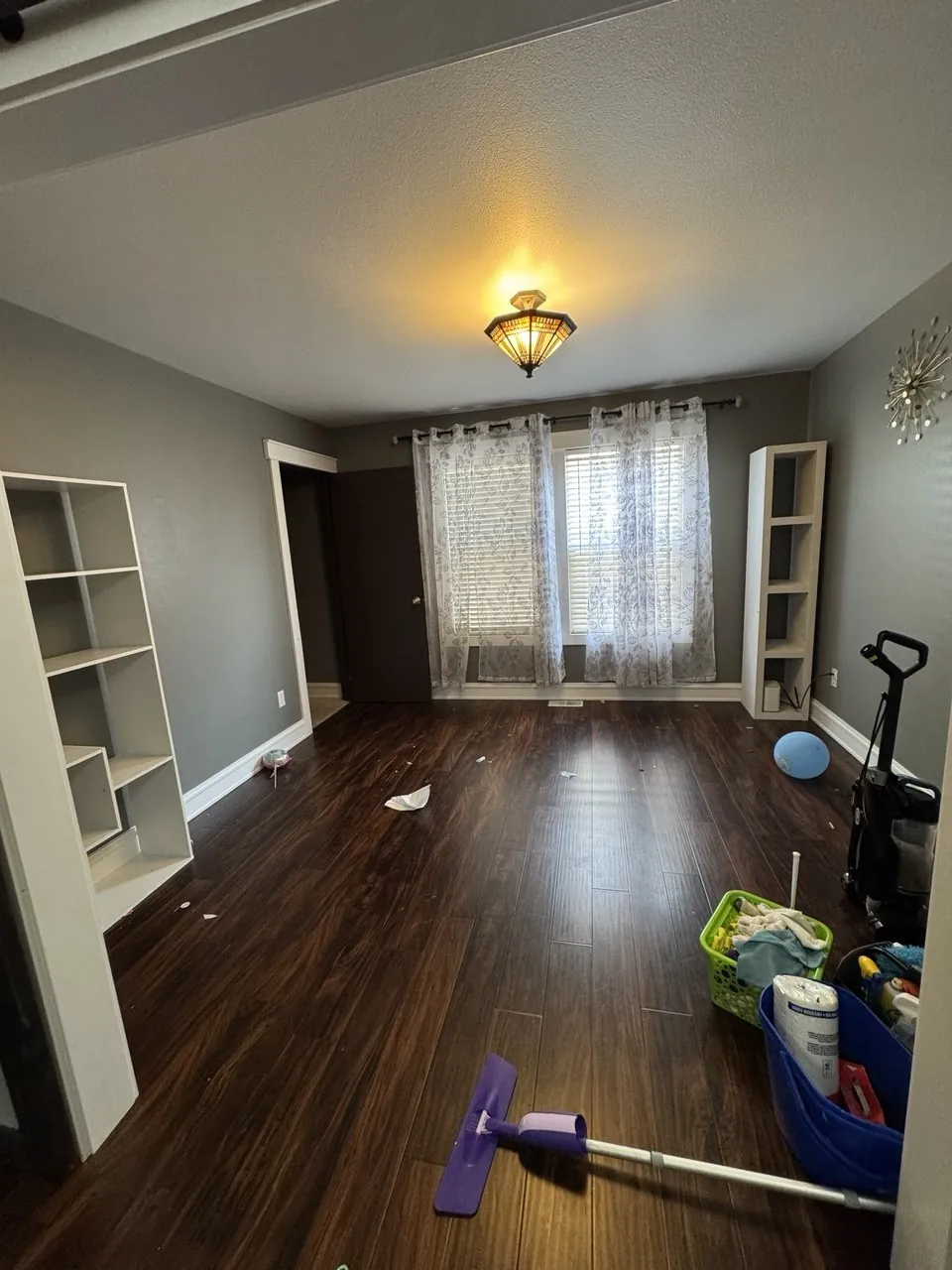 Before: empty room with dark wood floor, move-out