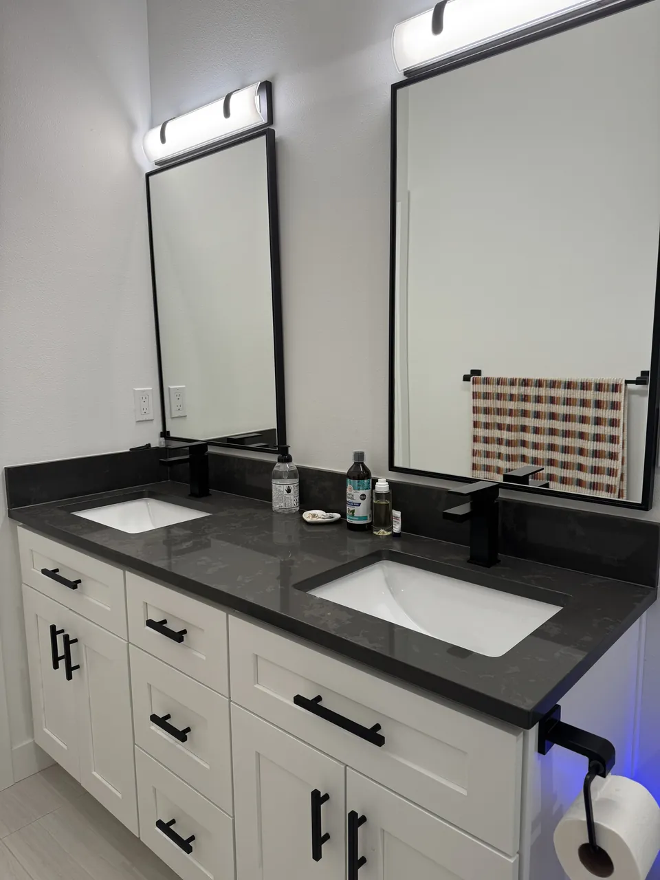 Double vanity with dark quartz top and black fixtures