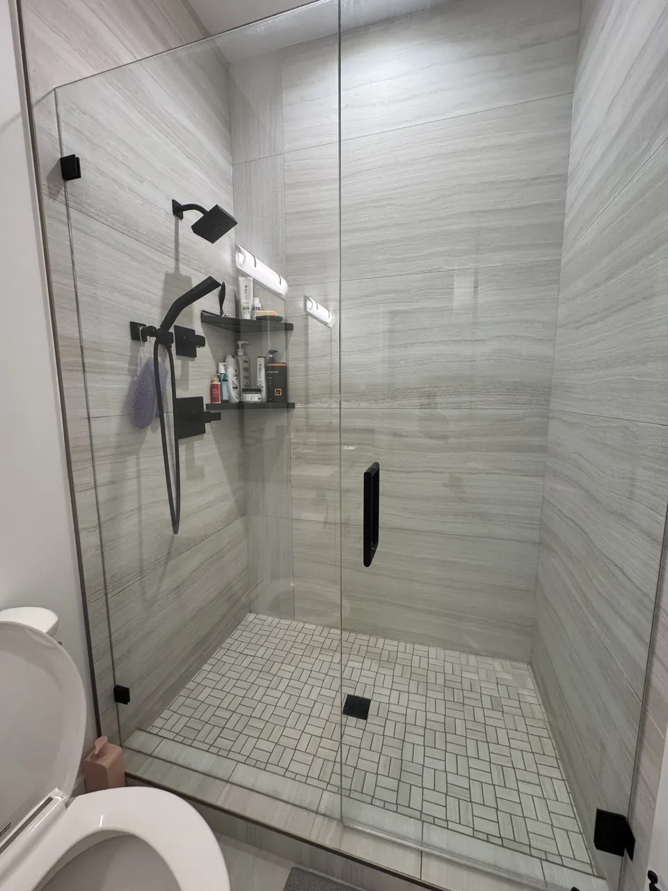 Walk-in shower with frameless glass and grey wood-look tile