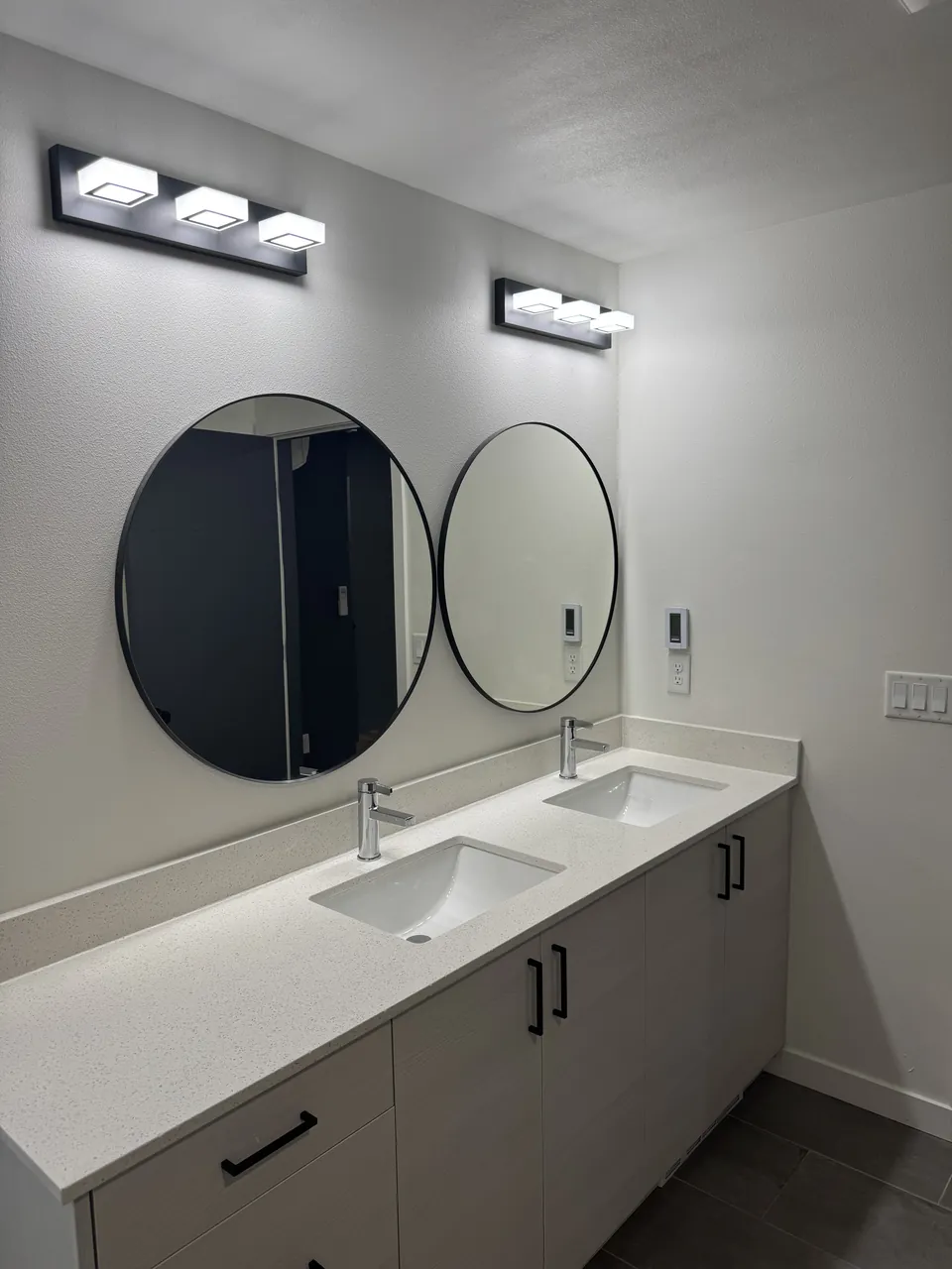 Double vanity with round mirrors and white quartz top