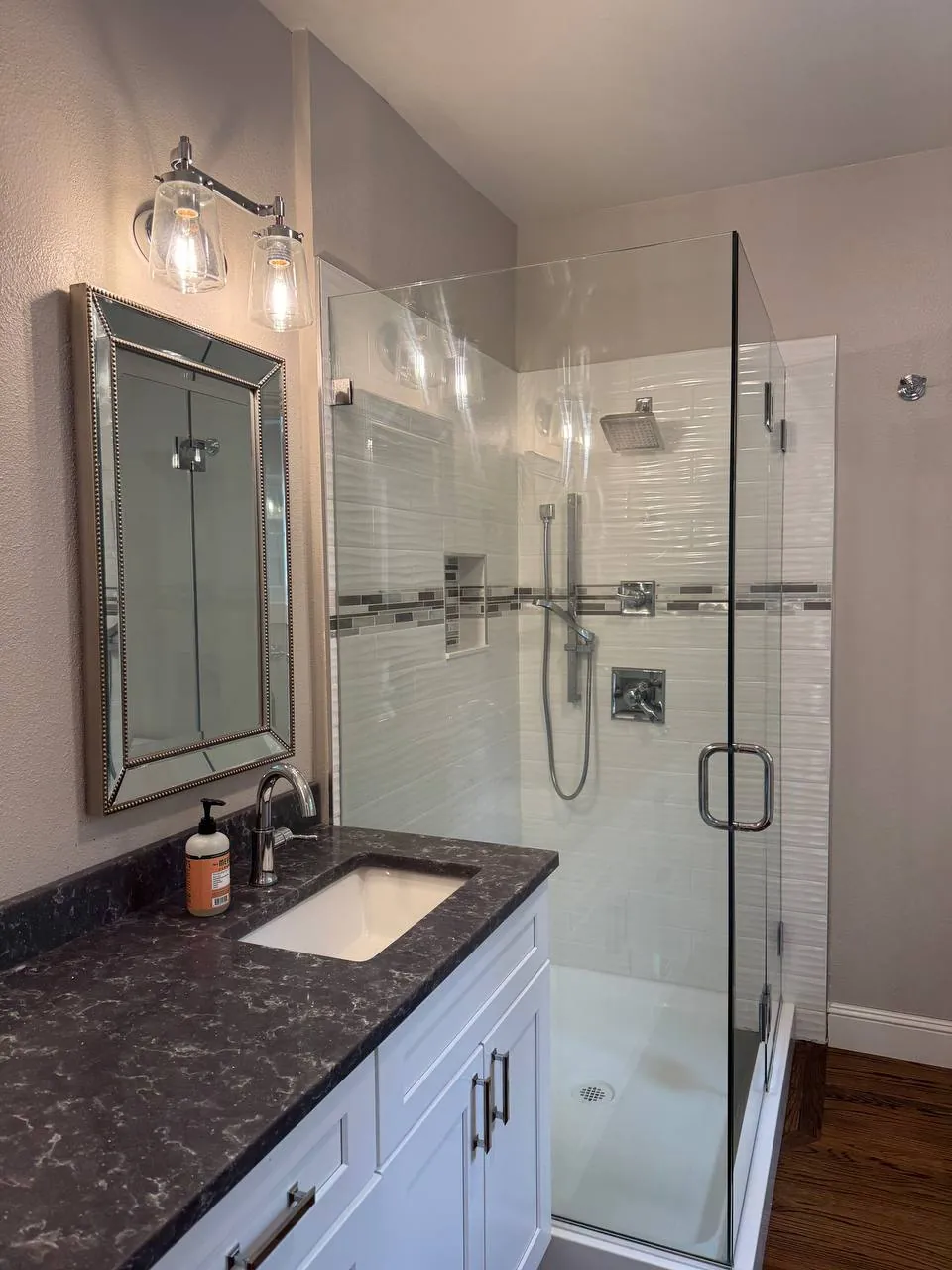 Bathroom vanity next to a glass shower enclosure