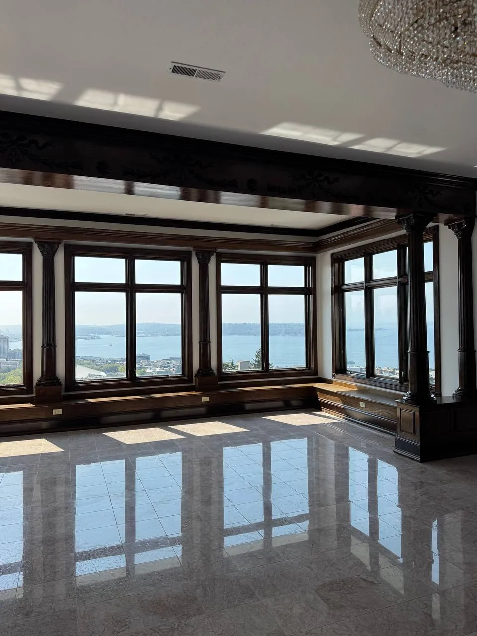 Empty room with polished stone floor and a wall of windows