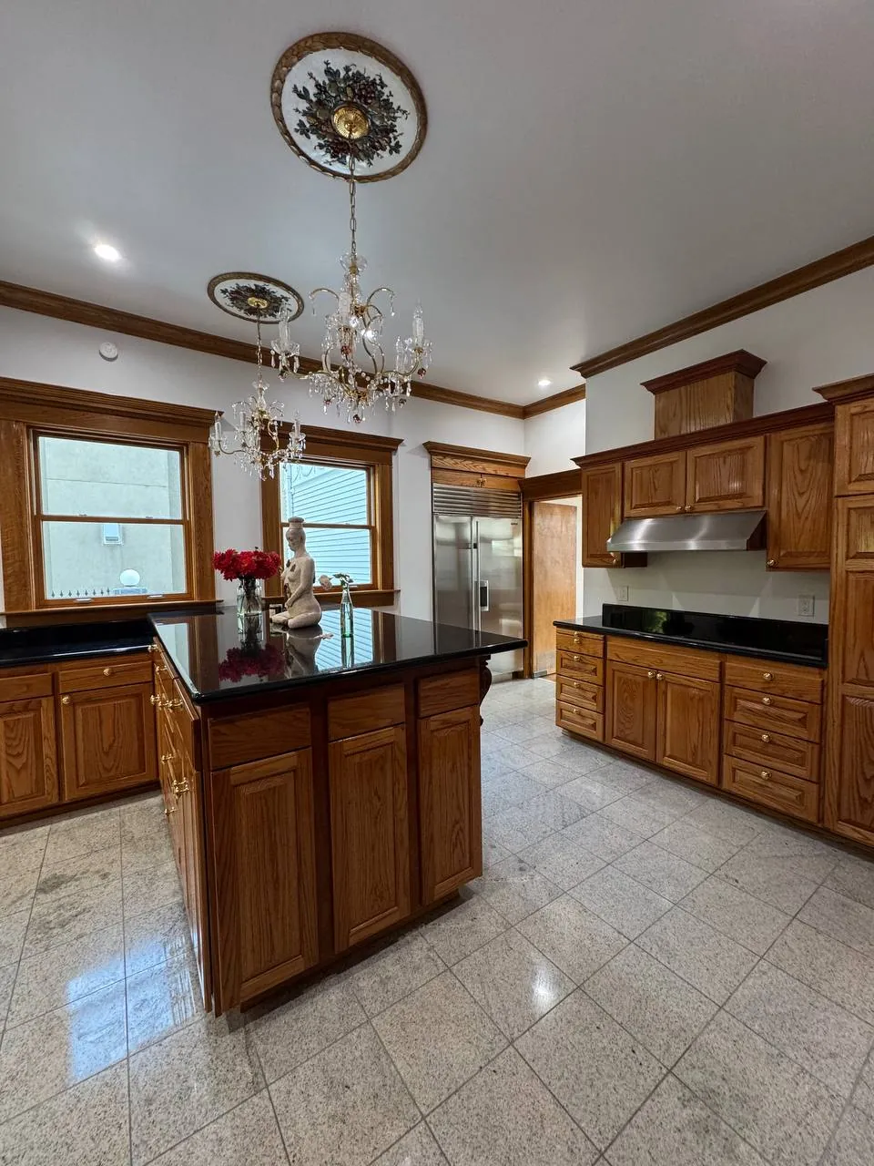 Large oak kitchen with island, granite counters and crystal chandeliers