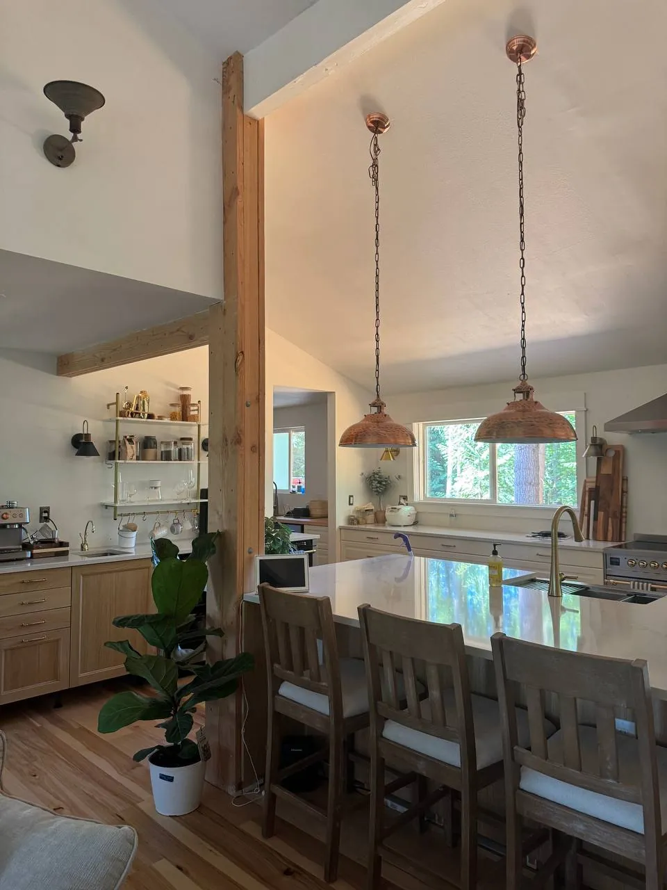 Open kitchen with wood island stools and copper pendant lights