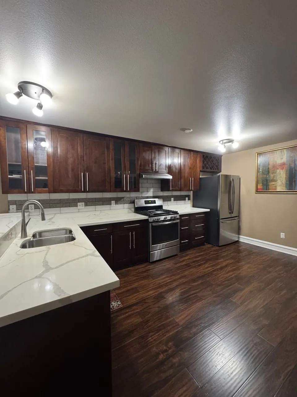 Dark wood kitchen with marble-look counters and wood floor
