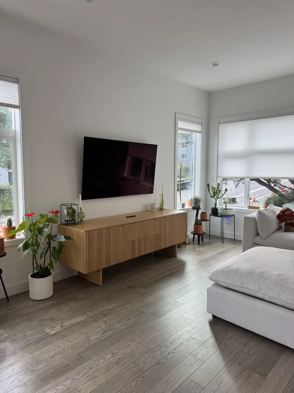 Living room with wood floor, low wood console and white sofa