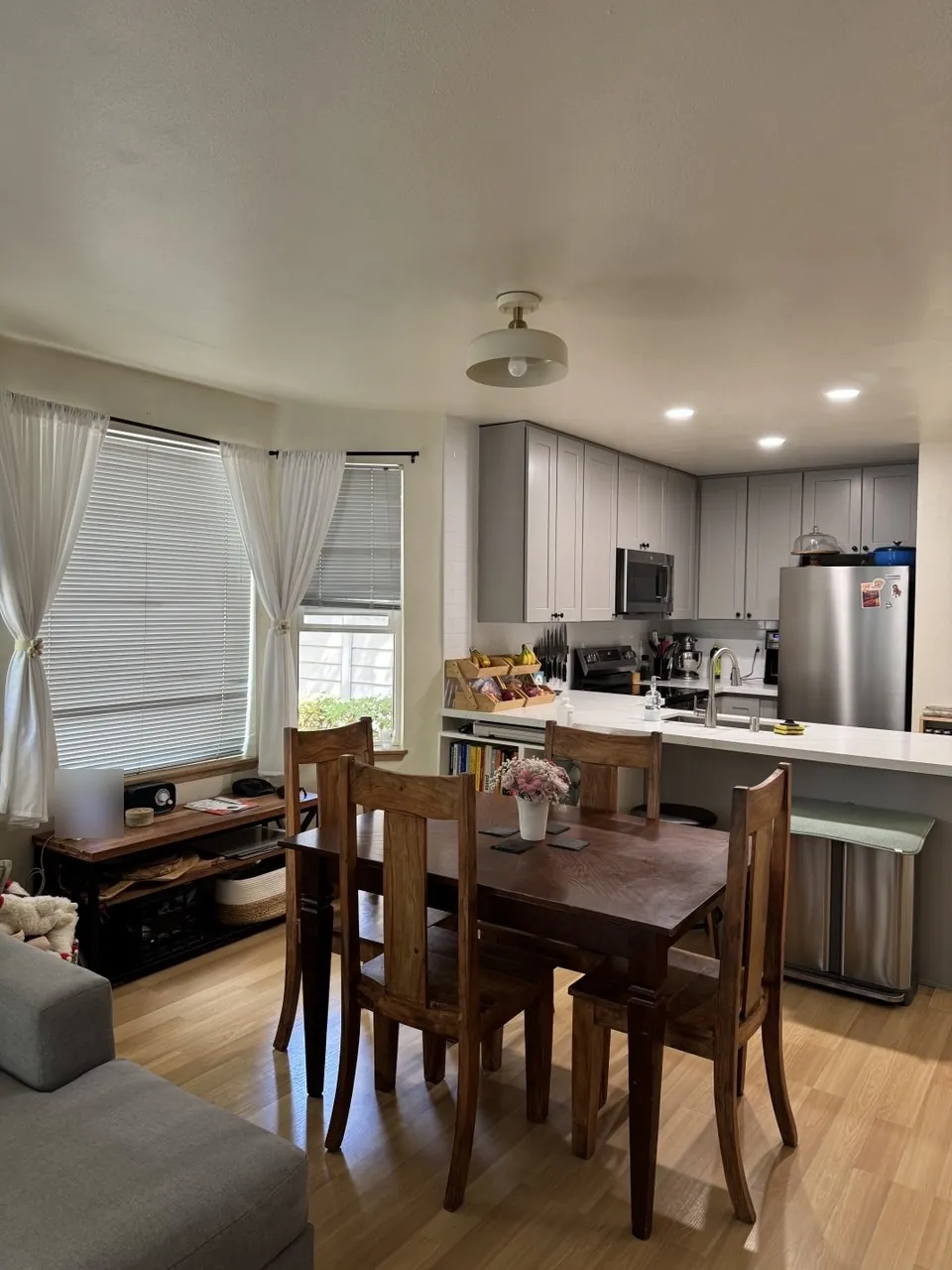 Dining table and open kitchen with gray cabinets