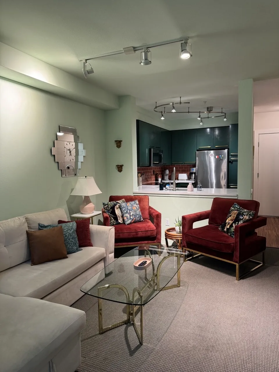 Living room with red velvet chairs and a glass coffee table