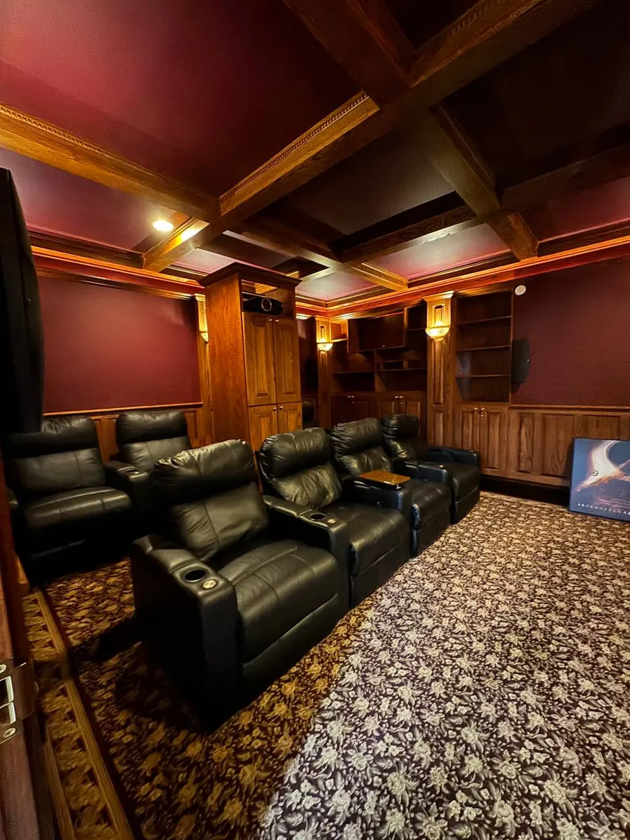 Home theater seating with leather recliners and patterned carpet