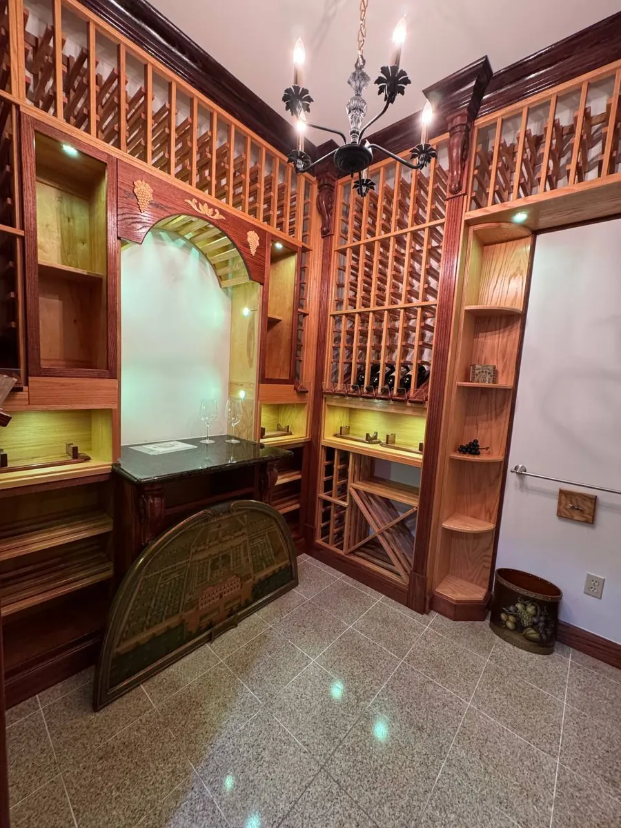 Wine room with oak racks, granite counter and polished stone floor