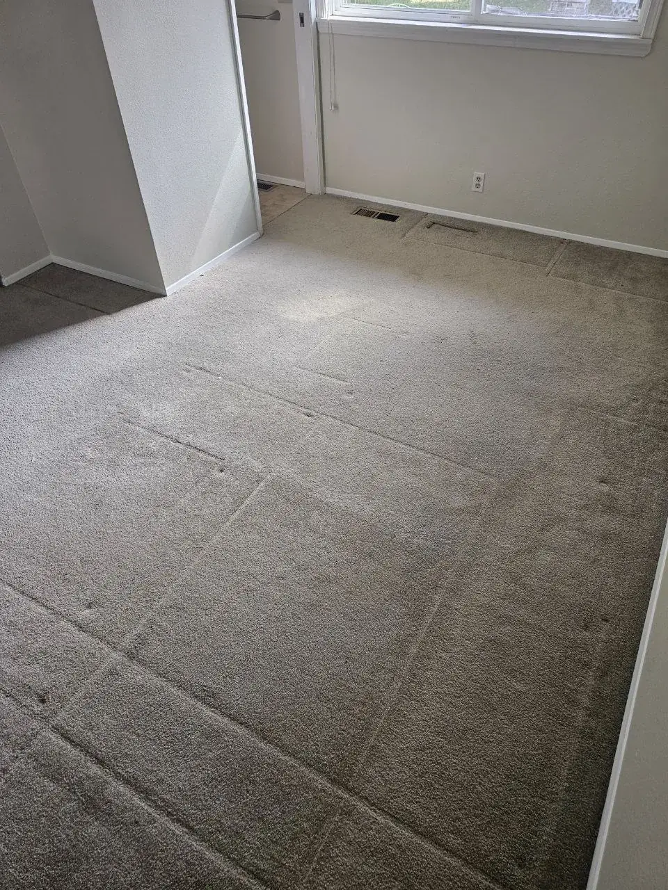Before: vacant rental bedroom carpet under the window